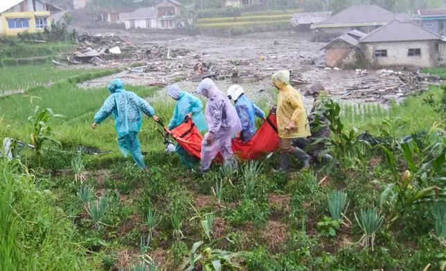 Rescuers carry the body of a flood victim in Malalak, West Sumatra, Indonesia, Thursday, Nov. 27, 2025. (AP Photo/Ade Yuandha)