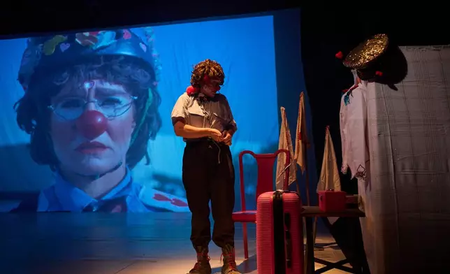 Israeli activist Hashoteret Az-Oolay, dressed as a clown and wearing a policewoman costume, prepares for a performance at a theater in Tel Aviv, Israel, Thursday, Nov. 27, 2025. (AP Photo/Ohad Zwigenberg)