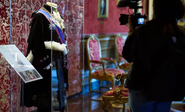 A journalist films the uniform of the Assistant at the Pontifical Throne, worn by Prince Colonna until 1968, on display at Palazzo Colonna, or the Colonna Palace, in Rome during a media tour, Friday, Nov. 7, 2025. (AP Photo/Domenico Stinellis)
