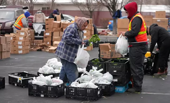 FILE - Utah Food Bank volunteers gather groceries for the needy at a mobile food pantry distribution site Dec. 21, 2022, in Salt Lake City. (AP Photo/Rick Bowmer, File)