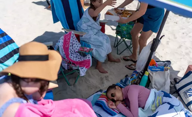Ruth Wilson, who has lupus, takes a nap after the onset of a migraine and fatigue, as too much sunshine is one of her triggers, while at the beach with family, Saturday, Aug. 16, 2025, in South Yarmouth, Mass. (AP Photo/David Goldman)