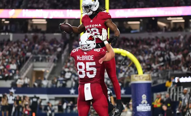 Arizona Cardinals' Marvin Harrison Jr. (18) and Trey McBride (85) celebrate Harrison Jr.s' touchdown catch in the first half of an NFL football game against the Dallas Cowboys Monday, Nov. 3, 2025, in Arlington, Texas. (AP Photo/Jessica Tobias)