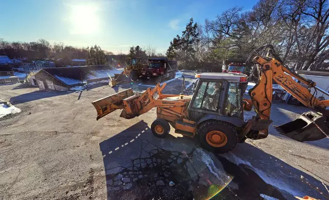 Land owner Ricky Cannizzo drives a backhoe through his property, which was approved to be developed into residential units and commercial space, Jan. 28, 2025, in Lexington, Mass. (AP Photo/Charles Krupa)