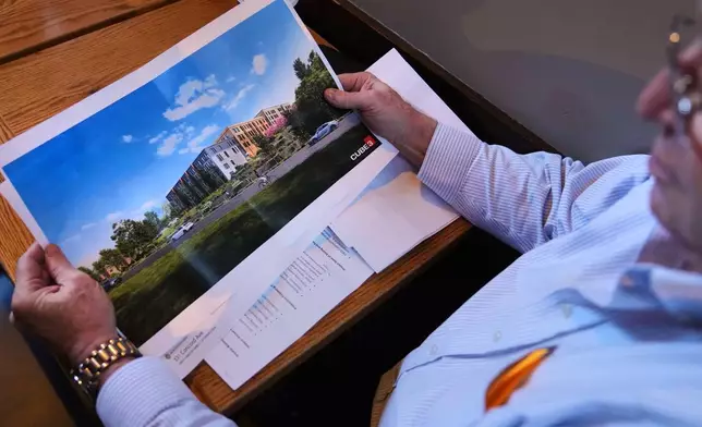 Jay Doherty, CEO of Cabot, Cabot &amp; Forbes property development firm, looks at an artist rendering of a future project that will include residential units and commercial space, Jan. 28, 2025, in Lexington, Mass. (AP Photo/Charles Krupa)