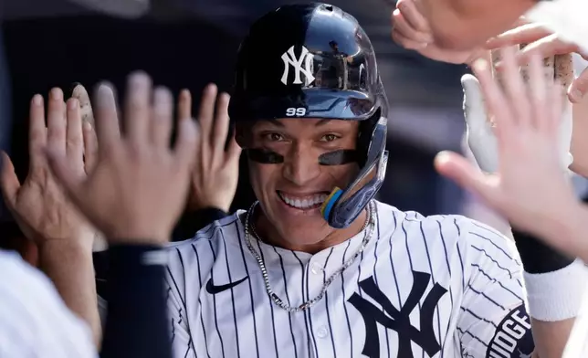 FILE - New York Yankees' Aaron Judge is congratulated after hitting a two-run home run during the seventh inning of a baseball game against the Athletics, June 29, 2025, in New York. (AP Photo/Adam Hunger, File)