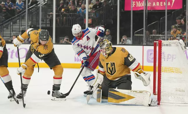New York Rangers center Vincent Trocheck (16) vies for the puck against Vegas Golden Knights defenseman Brayden McNabb (3) and goaltender Akira Schmid (40) during the first period of an NHL hockey game Tuesday, Nov. 18, 2025, in Las Vegas. (AP Photo/Candice Ward)