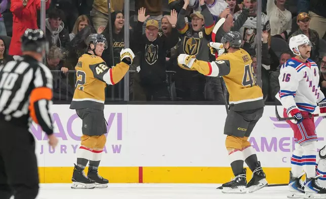 Vegas Golden Knights right wing Braeden Bowman (42) celebrates his goal with center Tomas Hertl (48) against the New York Rangers during the first period of an NHL hockey game Tuesday, Nov. 18, 2025, in Las Vegas. (AP Photo/Candice Ward)