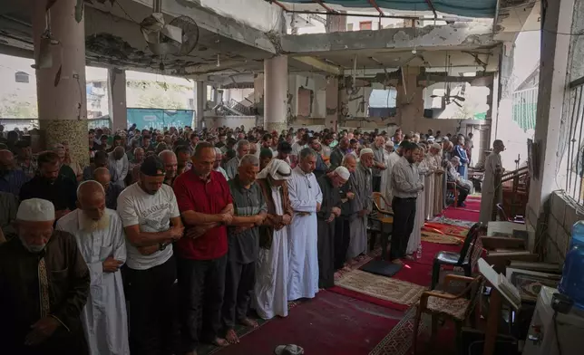 Palestinians attend Friday prayers in a mosque partially destroyed by Israeli bombardments, in Nuseirat, Gaza Strip, Friday, Nov. 7, 2025. (AP Photo/Abdel Kareem Hana)