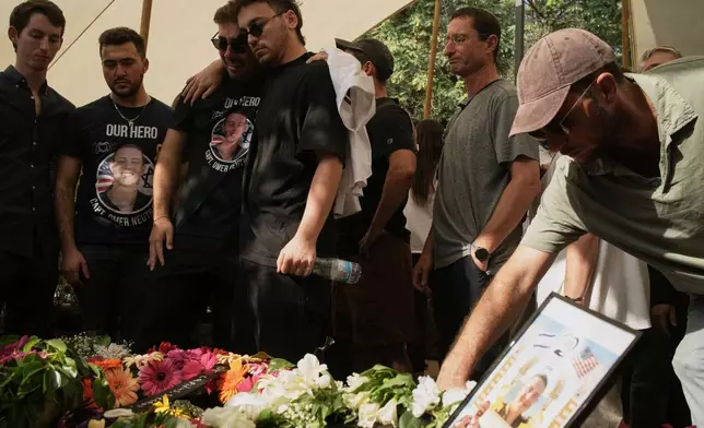 Relatives and friends mourn over the coffin of slain hostage Israeli-American Capt. Omer Neutra during his funeral, after his body was returned from Gaza as part of a ceasefire agreement between Israel and Hamas, at Kiryat Shaul cemetery, in Tel Aviv, Friday, Nov. 7, 2025. (AP Photo/Leo Correa)