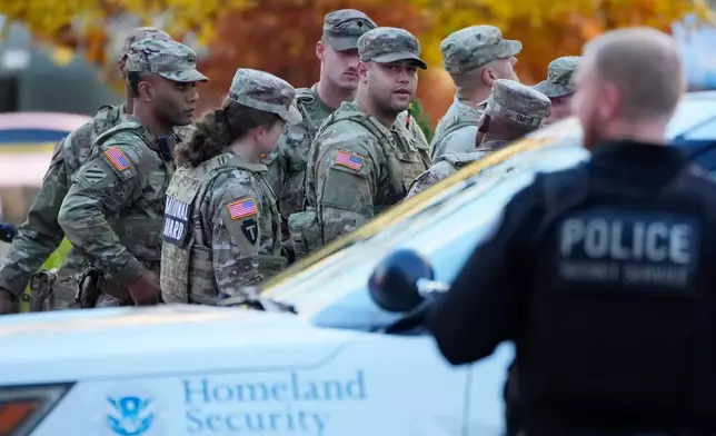 Members of the National Guard gather after reports of two National Guard soldiers were shot near the White House in Washington, Wednesday, Nov. 26, 2025. (AP Photo/Mark Schiefelbein)