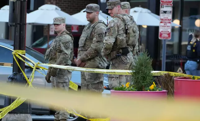 National Guard gather at a cordoned off an area near where National Guard soldiers were shot near the White House Wednesday, Nov. 26, 2025, in Washington. (AP Photo/Mark Schiefelbein)