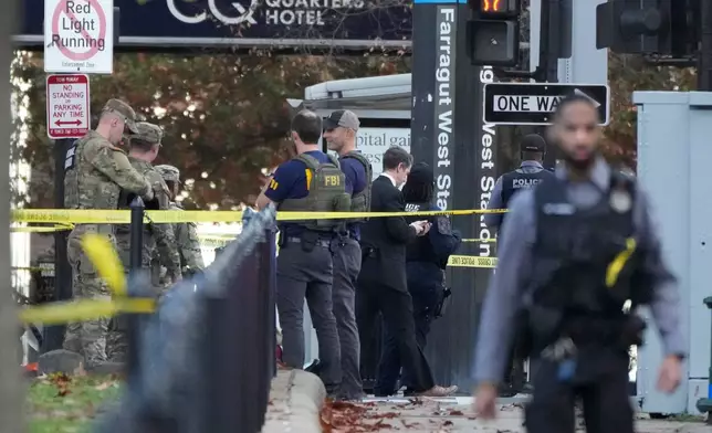 Emergency personnel gather near where National Guard soldiers appear to have been shot near the White House Wednesday, Nov. 26, 2025, in Washington. (AP Photo/Mark Schiefelbein)