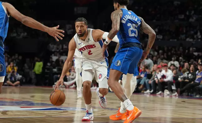 Detroit Pistons guard Cade Cunningham, center, goes to the basket against Dallas Mavericks forward P.J. Washington Jr. during the second half of an NBA basketball game in Mexico City, Saturday, Nov. 1, 2025. (AP Photo/Fernando Llano)