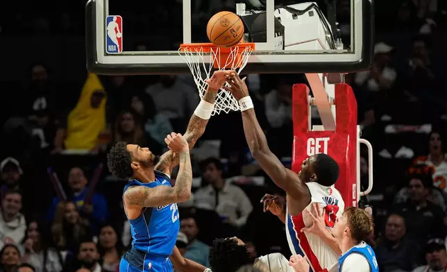 Dallas Mavericks forward P.J. Washington Jr., left, and Detroit Pistons center Jalen Duren fight for the ball during the second half of an NBA basketball game in Mexico City, Saturday, Nov. 1, 2025. (AP Photo/Fernando Llano)