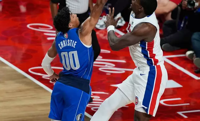 Detroit Pistons center Jalen Duren, right, scores past Dallas Mavericks guard Max Christie during the first half of an NBA basketball game in Mexico City, Saturday, Nov. 1, 2025. (AP Photo/Fernando Llano)