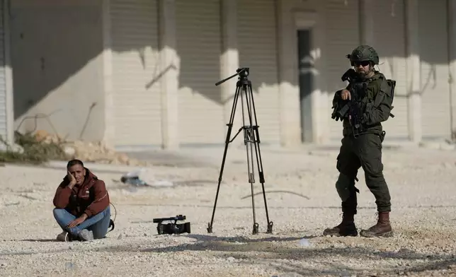 Mahmoud Fawzi, a cameraman for the Jordanian TV channel Roya TV, is detained by Israeli soldiers during a protest by displaced Palestinians calling to return to their houses in the Nur Shams refugee camp, in the West Bank city of Tulkarem, Tuesday, Nov. 18, 2025. (AP Photo/Majdi Mohammed)