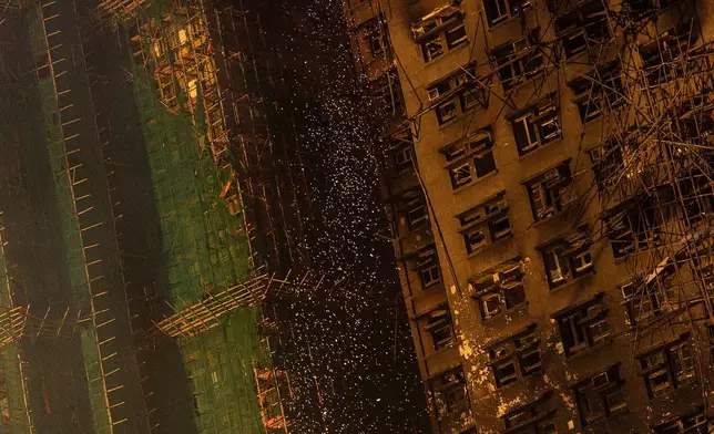 Fire sparks coming off from the burned building at the fire scene at Wang Fuk Court, a residential estate in the Tai Po district of Hong Kong's New Territories, Thursday, Nov. 27 2025. (AP Photo/Chan Long Hei)