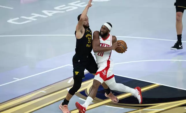 Houston Rockets guard Josh Okogie is guarded by Golden State Warriors guard Stephen Curry during the first half of an Emirates NBA Cup basketball game Wednesday, Nov. 26, 2025, in San Francisco. (AP Photo/Benjamin Fanjoy)