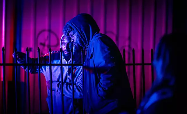 Bystanders watch at the scene of a mass shooting Saturday, Nov. 29, 2025, in Stockton, Calif. (AP Photo/Ethan Swope)