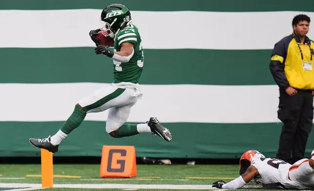 New York Jets running back Kene Nwangwu, left, takes a kickoff return into the end zone for a touchdown in front of Cleveland Browns cornerback Tre Avery, bottom right, in the first half of an NFL football game Sunday, Nov. 9, 2025, in East Rutherford, N.J. (AP Photo/Seth Wenig)