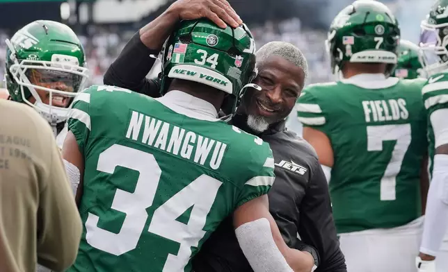 New York Jets head coach Aaron Glenn, center, celebrates with running back Kene Nwangwu (34) after Nwangwu's touchdown in the first of an NFL football game against the Cleveland Browns, Sunday, Nov. 9, 2025, in East Rutherford, N.J. (AP Photo/Yuki Iwamura)