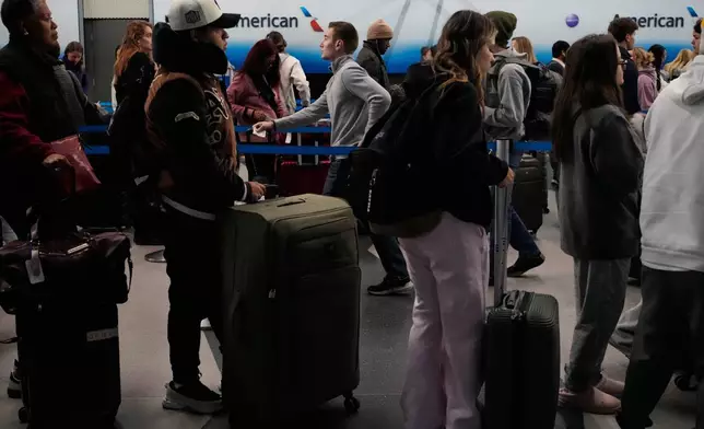 Travelers line up to check their tickets at O'Hare International Airport in Chicago, Wednesday, Nov. 12, 2025. (AP Photo/Nam Y. Huh)