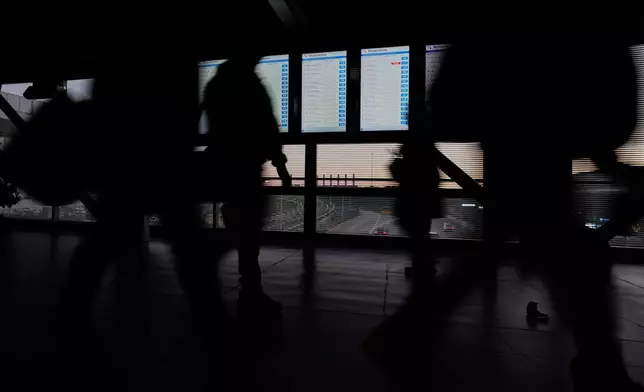 Travelers walk through the skyway leading to terminal 3 at O'Hare International Airport in Chicago, Wednesday, Nov. 12, 2025. (AP Photo/Nam Y. Huh)