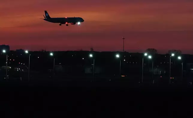 An airplane descends into landing at O'Hare International Airport in Chicago, Wednesday, Nov. 12, 2025. (AP Photo/Nam Y. Huh)
