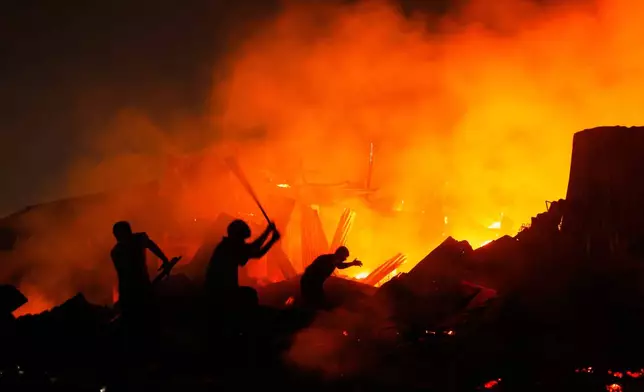 Rescuers try to douse a major fire that engulfed Korail Slum in Dhaka, Bangladesh, Tuesday, Nov. 25, 2025. (AP Photo/Rajib Dhar)