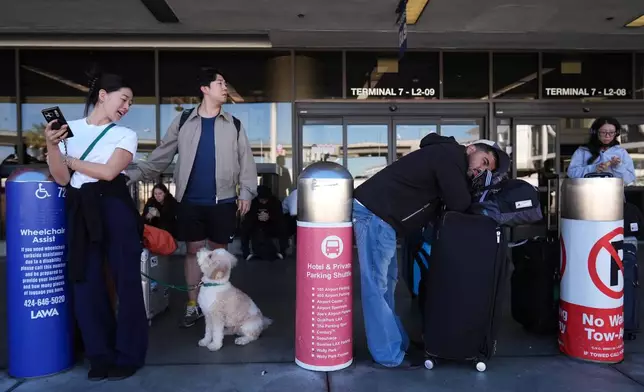 Holiday travelers arrive at Los Angeles International airport in Los Angeles Wednesday, Nov. 26, 2025. (AP Photo/Damian Dovarganes)