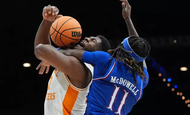 Tennessee forward Jaylen Carey (23) is fouled by Kansas guard Jamari McDowell (11) as he drives to the basket during the first half of an NCAA college basketball game in the Players Era tournament in Las Vegas, Wednesday, Nov. 26, 2025. (AP Photo/Eric Gay)