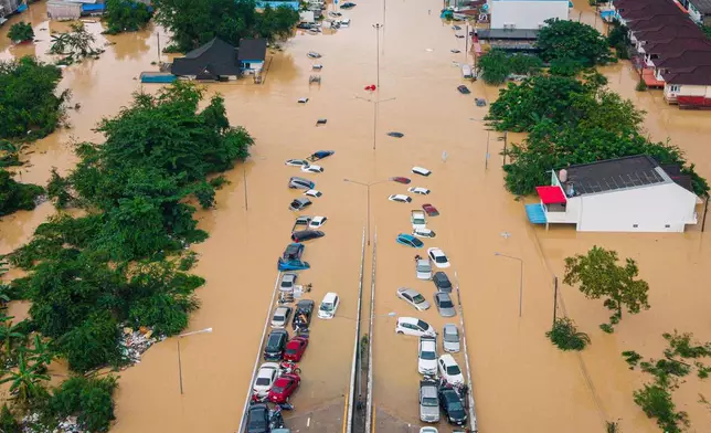 Cars and houses are submerged in floodwaters in Songkhla province, southern Thailand, Wednesday, Nov. 26, 2025. (AP Photo/Arnun Chonmahatrakool)