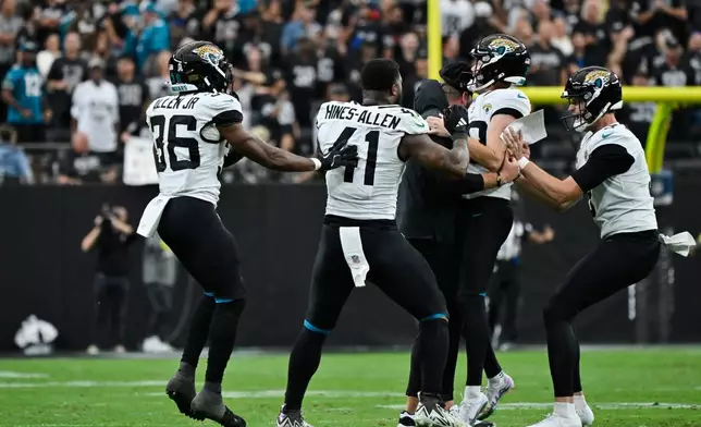 Jacksonville Jaguars place kicker Cam Little, second from right, is congratulated by head coach Liam Coen, center, and teammates after making a 68-yard field goal during the first half of an NFL football game against the Las Vegas Raiders, Sunday, Nov. 2, 2025, in Las Vegas. (AP Photo/David Becker)