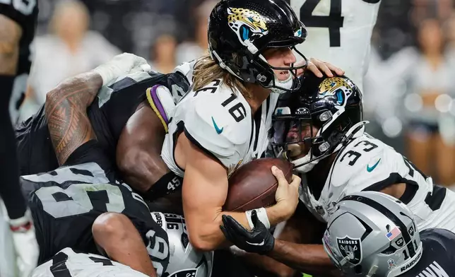 Jacksonville Jaguars quarterback Trevor Lawrence (16) scores a touchdown against the Las Vegas Raiders during overtime of an NFL football game, Sunday, Nov. 2, 2025, in Las Vegas. (AP Photo/Steve Marcus)