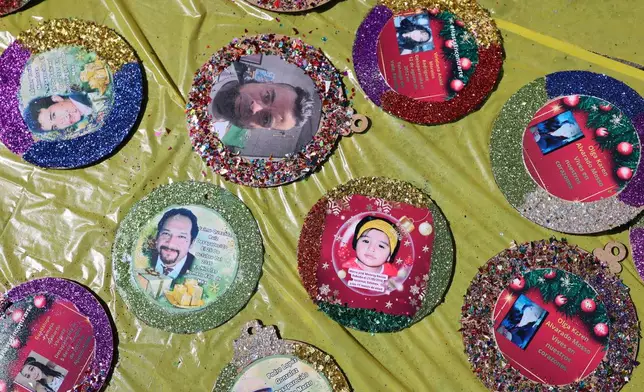 Christmas ornaments with photographs of the missing lay to dry before hanging on the Tree of Hope during an event organized by the diocese of Ecatepec at the Church of the Sacred Heart of San Cristobal in Ecatepec, State of Mexico, Monday, Nov. 17, 2025. (AP Photo/Ginnette Riquelme)
