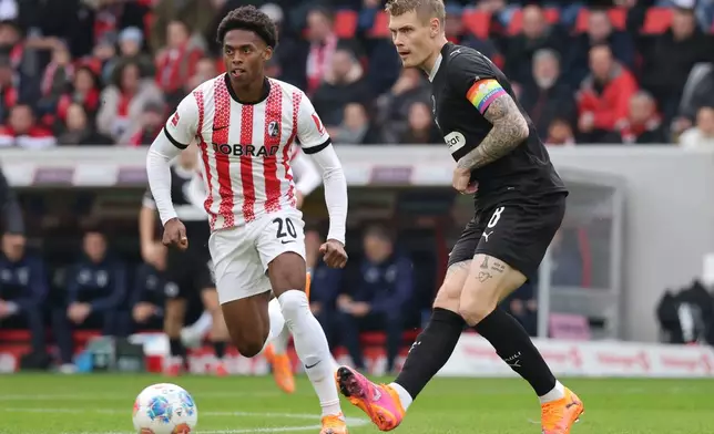Freiburg's Junior Adamu, left, and St. Pauli's Eric Smith, right, challenge for the ball during the German Bundesliga soccer match between SC Freiburg and FC St. Pauli in Freiburg, Germany, Sunday, Nov. 9, 2025. (Philipp von Ditfurth/dpa via AP)