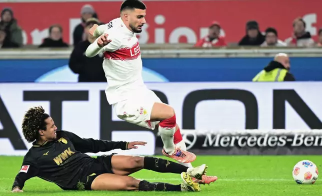 Augsburg's Han-Noah Massengo, left, and Stuttgart's Deniz Undav, right, challenge for the ball during the German Bundesliga soccer match between VfB Stuttgart and FC Augsburg in Stuttgart, Germany, Sunday, Nov. 9, 2025. (Bernd Weissbrod/dpa via AP)