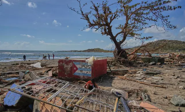 People walk along the shore in Boca de dos Rios, Cuba, Thursday, Oct. 30, 2025, after Hurricane Melissa passed through. (AP Photo/Ramon Espinosa)