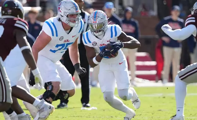 Mississippi running back Kewan Lacy (5) follows the block by offensive lineman Patrick Kutas (75) during the first half of an NCAA college football game against Mississippi State, Frifday, Nov. 28, 2025, in Starkville, Miss. (AP Photo/Rogelio V. Solis)