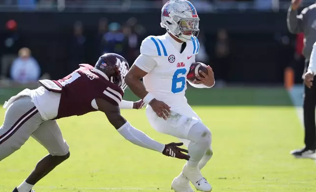Mississippi quarterback Trinidad Chambliss (6) is pushed out-of-bounds by Mississippi State cornerback Kelley Jones (1) during the first half of an NCAA college football game Frifday, Nov. 28, 2025, in Starkville, Miss. (AP Photo/Rogelio V. Solis)