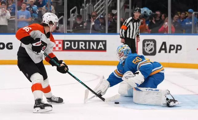 Philadelphia Flyers' Trevor Zegras (46) scores past St. Louis Blues goaltender Jordan Binnington (50) during a shootout of an NHL hockey game Friday, Nov. 14, 2025, in St. Louis. (AP Photo/Jeff Roberson)