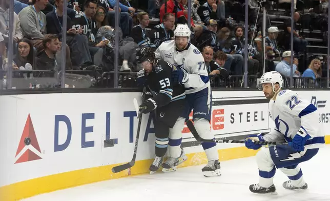 Utah Mammoth left wing Michael Carcone (53) goes after the puck against Tampa Bay Lightning defenseman Victor Hedman (77) and right wing Oliver Bjorkstrand (22) during the second period of an NHL hockey game Sunday, Nov. 2, 2025, in Salt Lake City. (AP Photo/Melissa Majchrzak)