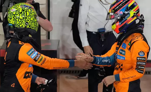 Third-placed McLaren driver Lando Norris of Britain congratulates his teammate first-placed Oscar Piastri of Australia after the sprint qualifying for the Formula One Qatar Grand Prix in Friday, Nov. 28, 2025. (AP Photo/Altaf Qadri, Pool)