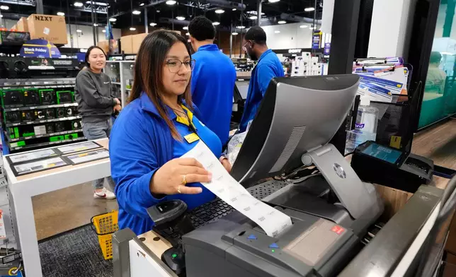 Abril Renteria, an Apple certified advisor, helps a customer check out after their purchase at a Best Buy store, Wednesday, Nov. 26, 2025, in Dallas. (AP Photo/Tony Gutierrez)
