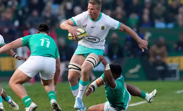 FILE - South Africa's Pieter-Steph du Toit, center, is challenged by Ireland's Bundee Aki, right, during a test match between South Africa and Ireland at Loftus Versfeld stadium in Pretoria, South Africa, July 6, 2024. (AP Photo/Themba Hadebe, File)