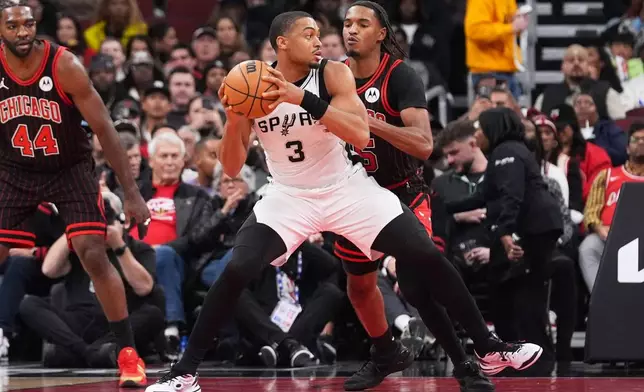 San Antonio Spurs forward Keldon Johnson (3) drives as Chicago Bulls forward Julian Phillips guards during the first half of an NBA basketball game in Chicago, Monday, Nov. 10, 2025. (AP Photo/Nam Y. Huh)