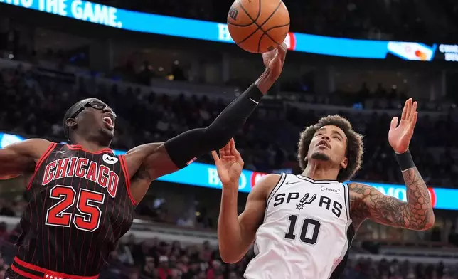 Chicago Bulls forward Jalen Smith, left, rebounds a ball against San Antonio Spurs forward Jeremy Sochan during the first half of an NBA basketball game in Chicago, Monday, Nov. 10, 2025. (AP Photo/Nam Y. Huh)