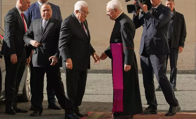 Palestinian President Mahmoud Abbas, also known as Abu Mazen, left, is welcomed by Monsignor Leonardo Sapienza as he arrives in the St. Damasus Courtyard at the Vatican for a meeting with Pope Leo XIV, Thursday, Nov. 6, 2025. (AP Photo/Andrew Medichini)