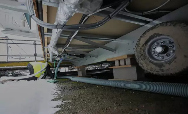 Workers pull cables in the athlete's village for the Cortina Milan Winter Olympics, in Cortina D'Ampezzo, Italy, Monday, Nov. 24, 2025. (AP Photo/Andrew Medichini)