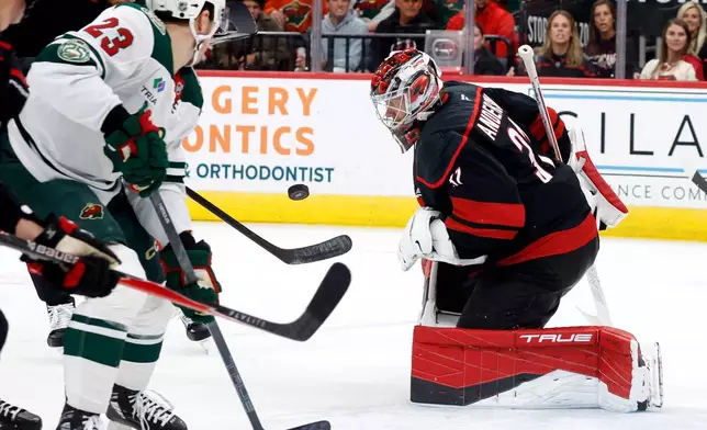 Carolina Hurricanes goaltender Frederik Andersen (31) watches the puck with Minnesota Wild's Marco Rossi (23) nearby during the third period of an NHL hockey game in Raleigh, N.C., Thursday, Nov. 6, 2025. (AP Photo/Karl DeBlaker)